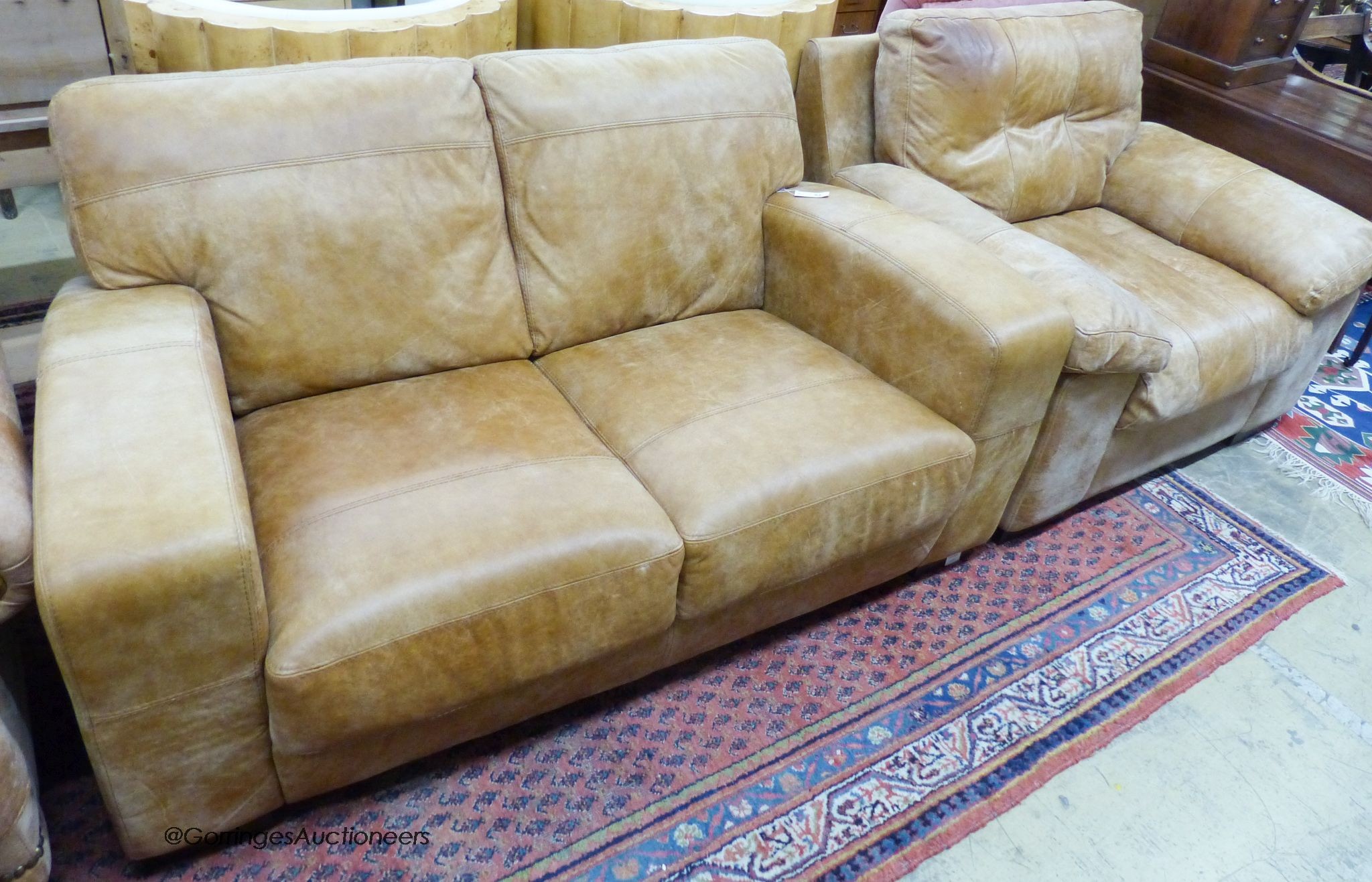 A contemporary tanned leather two seater sofa, length 156cm, depth 94cm, height 82cm and similar armchair